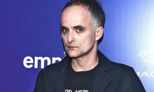 Artur Rojek, myslovitz wokalista, zamyślony, w czarnej marynarce i t-shircie z napisem.