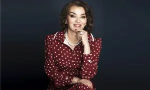 Uśmiechnięta kobieta w sukience w białe kropki, niczym z lat 50. Jej styl to klasyczna polka.