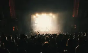 Tłum na koncercie, światła sceny rozświetlają mgłę. Wszyscy śpiewają "Someone Like You" Adele.