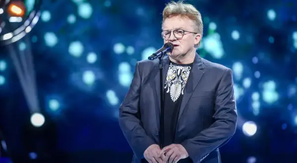 Artysta śpiewa, a na ekranie za nim widać tekst piosenki "Jolka, Jolka pamiętasz".