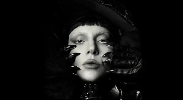 Lady Gaga w czerni, z ostrymi pazurami i mrocznym makijażem, przygotowuje się do koncertu.