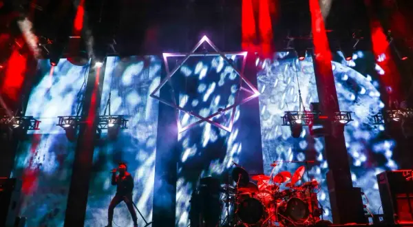 Wokalista na scenie, perkusja, wielka gwiazda na tle ekranu. Niesamowita atmosfera na **impact festival**.