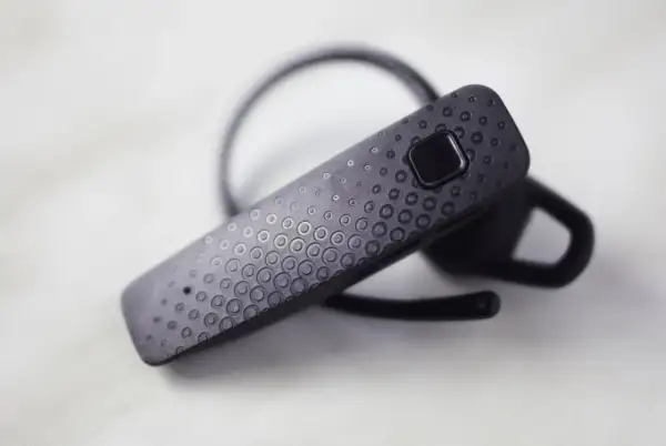 Czarna słuchawka Bluetooth F9 z teksturowaną powierzchnią i przyciskiem.
